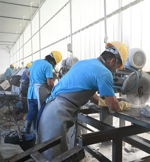 Craftsmen cutting natural stone slabs in a workshop